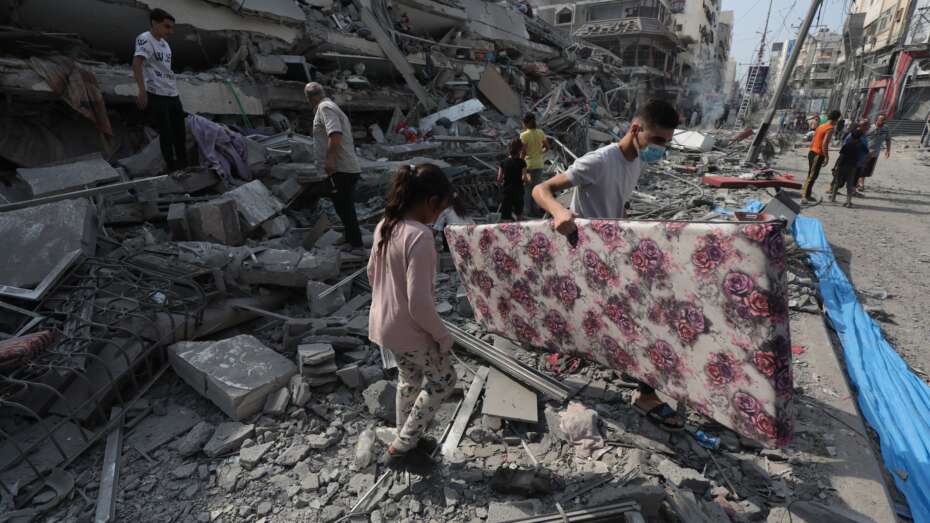 Palestinians inspect the ruins of Aklouk Tower destroyed in Israeli airstrikes in Gaza City on October 8, 2023. The death toll from the devastating Israeli war on the Gaza Strip has risen to 313 since early yesterday morning, with more than 1,990 others injured, according to medical sources. Photo by Naaman Omar apaimages
