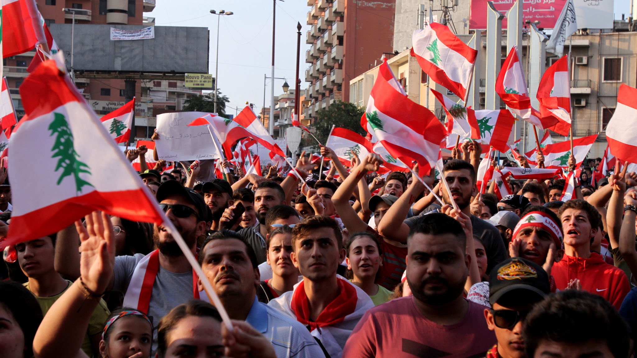Demonstrators carry national flags during an anti-government protest in Tripoli, Lebanon October 22, 2019. REUTERS/Omar Ibrahim